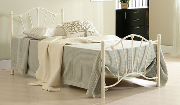 Cream metal bed with blue throw